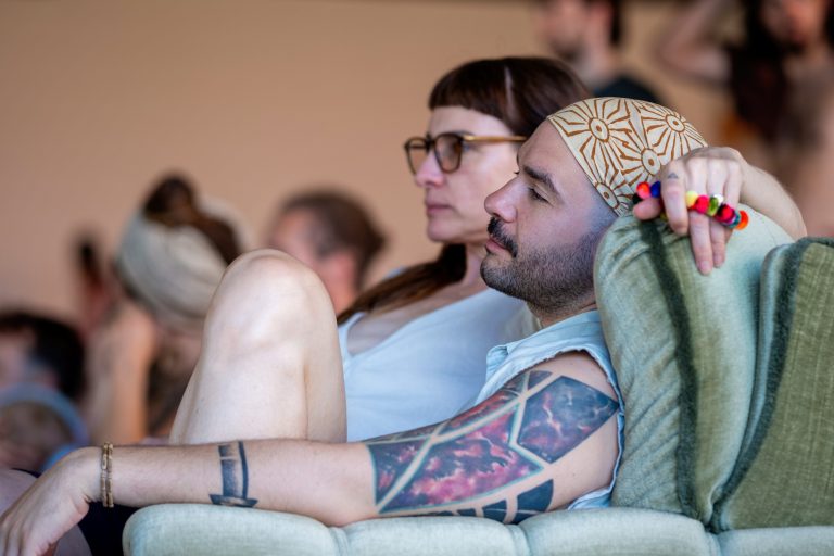 Ein Mann und eine Frau sitzen bei einem Gathering nebeneinander.