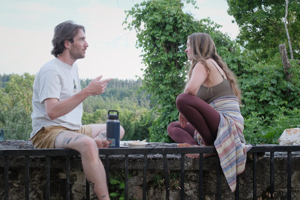 Zwei Menschen im Gespräch im Freien Ein Mann und eine Frau sitzen sich im Freien gegenüber und sprechen miteinander.